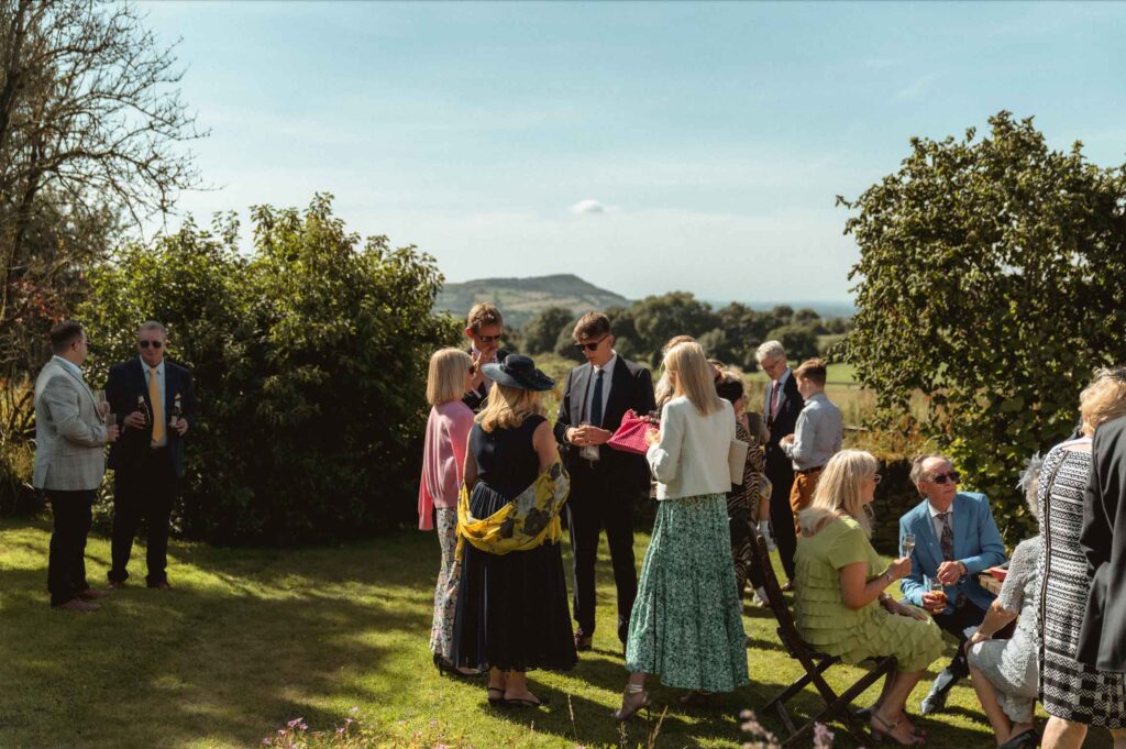 Wedding guests in the grounds at Toft Estate, Peak District